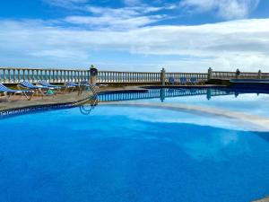 a large swimming pool with chairs and a fence at Astur Hotel & Residence in Veracruz