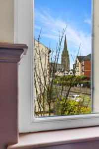 a window with a view of a church at Hestia House in Derry Londonderry