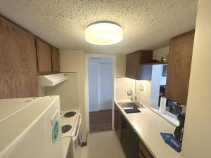 a kitchen with a sink and a white refrigerator at Spacious 2 bd 2 bth Condo at Cedar Lodge Laconia in Laconia +13 photos