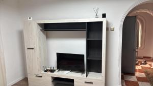 a entertainment center with a television in a room at Asalt Pascani in Paşcani