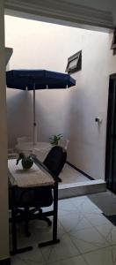 a table with a chair and a blue umbrella at Residence Maachaalah in Saint-Louis +6 photos