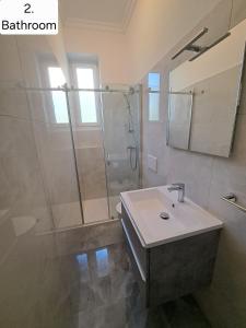 a bathroom with a shower and a sink and a mirror at Apartman Villa Adelina in Lovran +29 photos