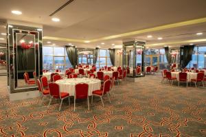 a banquet room with tables and chairs and windows at TRYP by Wyndham Izmit in Kocaeli