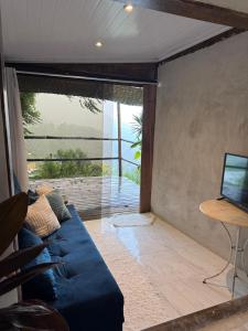 a living room with a blue couch in front of a window at Pousada Sonho Real in Angra dos Reis