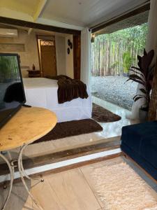 a bedroom with a bed and a table with a laptop at Pousada Sonho Real in Angra dos Reis