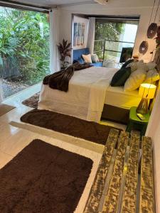 a bedroom with a large bed and a large window at Pousada Sonho Real in Angra dos Reis