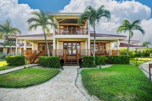 a house with palm trees in front of it at Hopkins Bay Belize a Muy'Ono Resort in Hopkins