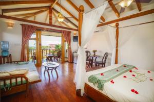 a bedroom with two beds in a room with a balcony at Hopkins Bay Belize a Muy'Ono Resort in Hopkins +92 photos