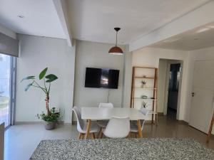 a dining room with a white table and chairs at Luz de Sol in Plottier