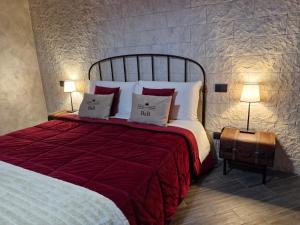 a bedroom with a large bed with red sheets and pillows at Principe Giardinelli in Piazza Armerina