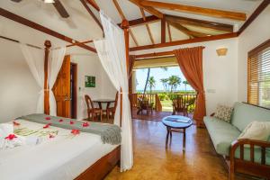 a bedroom with a bed and a living room at Hopkins Bay Belize a Muy'Ono Resort in Hopkins