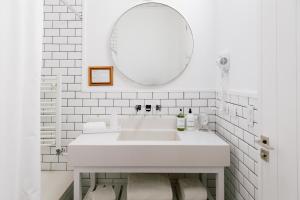 a white bathroom with a sink and a mirror at Hosteria El Puma in El Chalten +70 photos