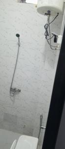 a bathroom with a toilet and a white wall at Residence Maachaalah in Saint-Louis