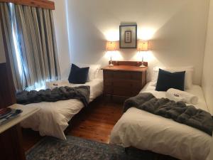 a hotel room with three beds and a table at Emma's Beach Cottage in Great Brak River
