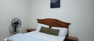 a bedroom with a bed with white sheets and a fan at Residence Maachaalah in Saint-Louis