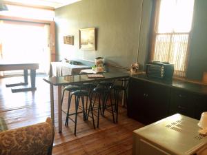 a kitchen with a table and stools in a room at Witkrans Guest Farm in Middelburg