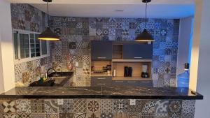 a kitchen with a black counter top with tiles at Mirante Rota do Mar in Maceió