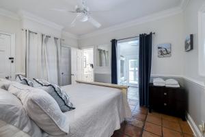 a white bedroom with a bed and a window at Charming Historic Condo with Pool in Savannah +24 photos