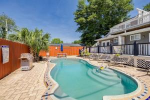 a swimming pool with chairs and a fence at Charming Historic Condo with Pool in Savannah
