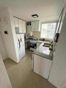 a kitchen with a white refrigerator and a sink at Edificio lillion 2 in Mar del Plata