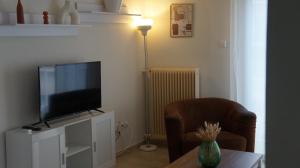ein Wohnzimmer mit Fernseher, Sessel und Tisch in der Unterkunft Central in Chalkida + 15 Fotos