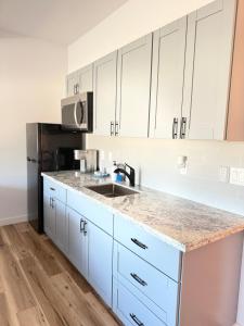 a kitchen with white cabinets and a sink at Unit 3 Waena Inn Newly Renovated Maui Private Suite in Wailuku