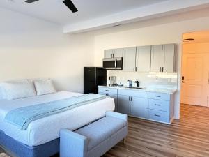 a white bedroom with a bed and a kitchen at Unit 3 Waena Inn Newly Renovated Maui Private Suite in Wailuku