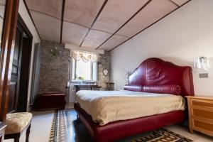 a bedroom with a large bed and a red leather chair at B&B Al Convento in Potenza