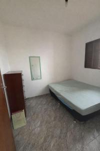 a small bedroom with a bed and a mirror at Casa Central Aconchegante in Cunha