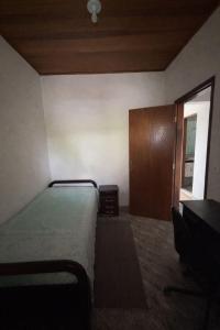 a bedroom with a bed and a wooden cabinet at Casa Central Aconchegante in Cunha