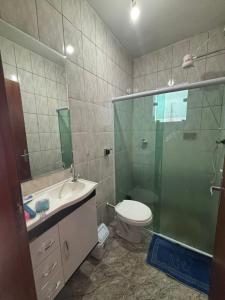 a bathroom with a shower and a toilet and a sink at Casa Central Aconchegante in Cunha