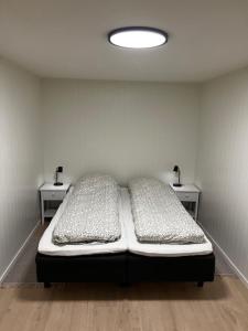 a room with two beds and two night stands at Nyoppusset leilighet i Vadsø in Vadsø