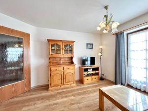 a living room with a wooden cabinet and a tv at Sonnenstüble in Oberstdorf