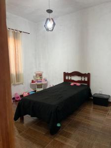 a bedroom with a bed with a black blanket at Casa do Bosque in Paty do Alferes