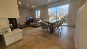 a living room with a table and chairs and a fireplace at Villa Berninoise in Bernin +5 photos