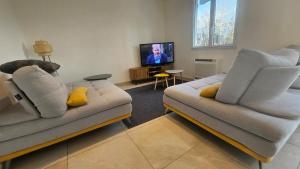 a living room with two couches and a tv at Villa Berninoise in Bernin