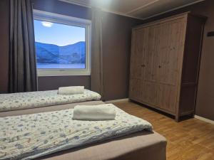 a bedroom with two beds and a window at Senja 4 Summit in Torsken