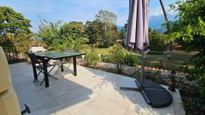a patio with a glass table and an umbrella at Villa Berninoise in Bernin