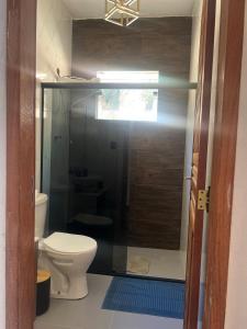 a bathroom with a toilet and a glass shower at Casa do Bosque in Paty do Alferes