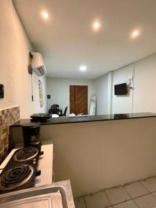a kitchen with a stove top oven next to a counter at Flat Praia do Pontal in Baía Formosa