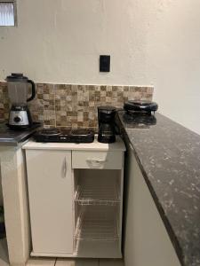 a kitchen with a stove and a counter top at Flat Praia do Pontal in Baía Formosa +1 photo