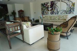 a living room with a white couch and chairs at Astur Hotel & Residence in Veracruz