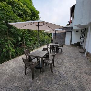 two tables and chairs with umbrellas on a patio at Viviendas Turísticas in Jericó