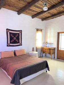 a bedroom with a bed and a table and a window at AGAVE HOUSE in Prince Albert