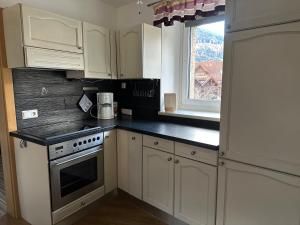 a kitchen with white cabinets and a stove and a window at Apartment Obervellach in Obervellach
