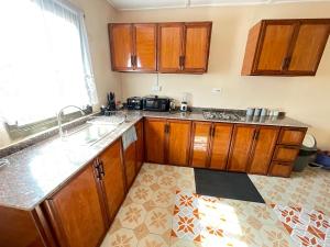 a kitchen with wooden cabinets and a sink at Brimelia Lodge in Bammbatuk