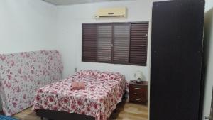a small bedroom with a bed and a window at Pousada da bancários in São Gabriel