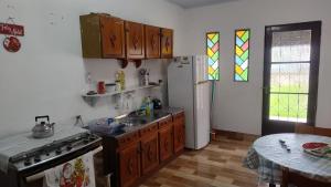 a kitchen with a sink and a stove and a window at Pousada da bancários in São Gabriel +5 photos