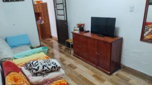 a living room with a couch and a flat screen tv at Pousada da bancários in São Gabriel