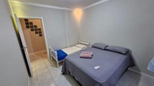 a small bedroom with a bed and a small door at Loft 150m da praia in Itajaí